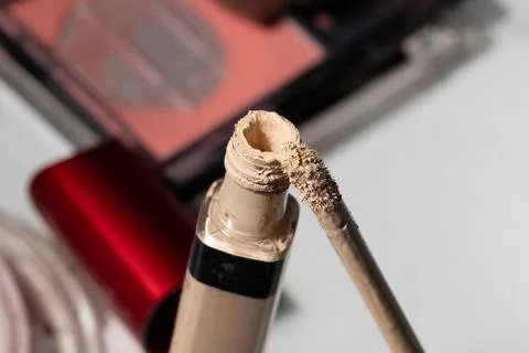 Macro studio shot of an open foundation tube with a worn applicator, revealin Stock Photos