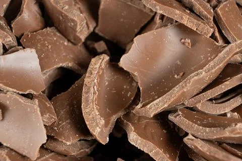 Macro texture of broken milk chocolate pieces pile background Stock Photos