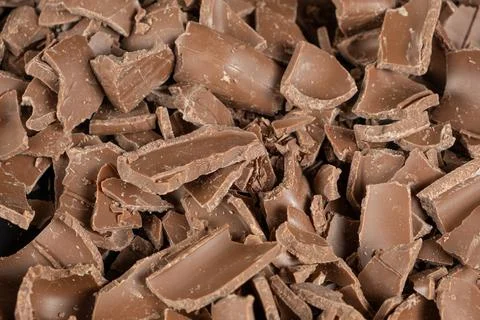 Macro texture of broken milk chocolate pieces pile background Stock Photos