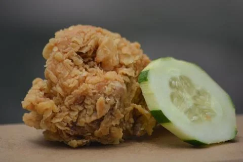 Macro texture of crispy fried chicken with cucumber slice detail Stock Photos