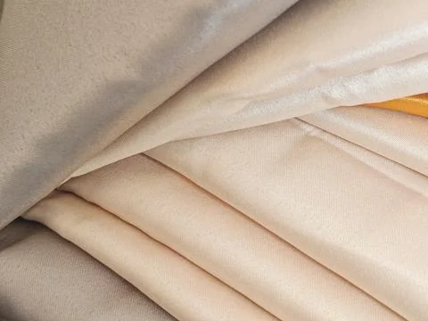 Macro Texture of Folded Champagne and Cream Satin Fabrics Fotos Stock