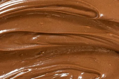 Macro texture of glossy chocolate nut cream swirling patterns Stock Photos