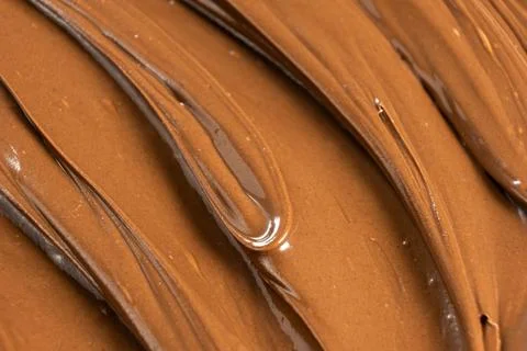 Macro texture of glossy chocolate nut cream swirling patterns Stock Photos
