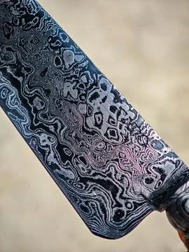 Macro texture of a hand-forged damascus steel blade with unique wavy patterns Stock Photos