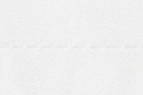 Macro texture of light beige fabric with machine seam. Stock Photos