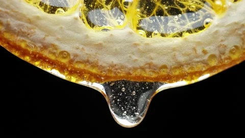 Macro Texture shot of Honey dripping down a fresh lemon slice on white Stock Footage 143354356