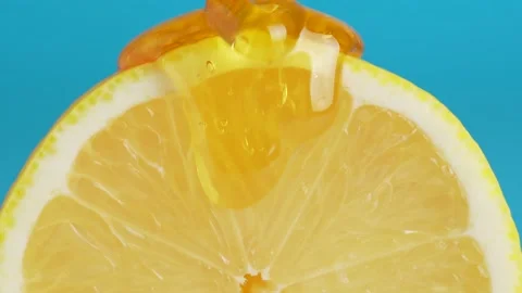 Macro texture shot of honey dripping down a fresh lemon slice Video stock 230100050