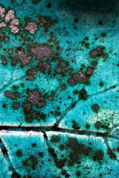 Macro texture of turquoise ceramic plate with leaf imprint speckled glaze Stock Photos