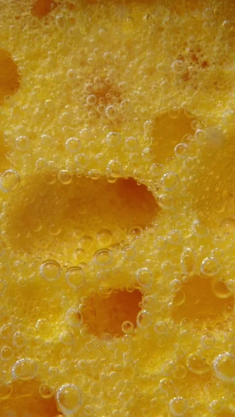 Macro Texture of Yellow Porous Sponge with Soap Bubbles Stockbeeldmateriaal 346640954