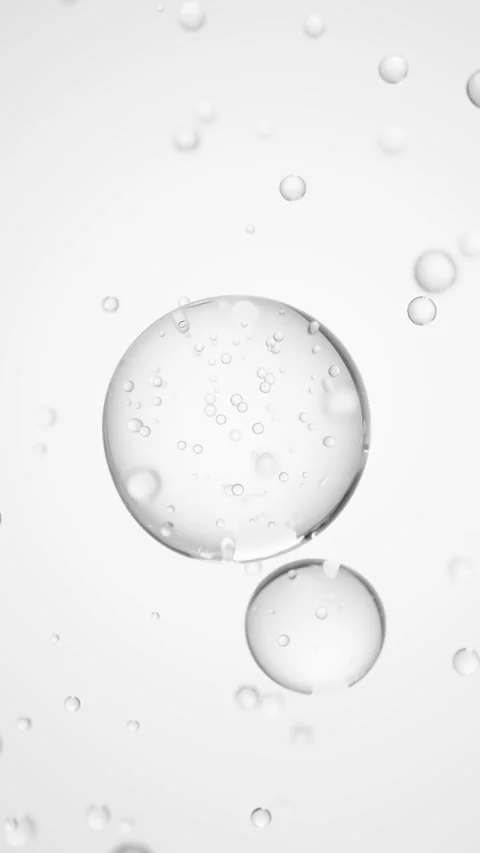 Macro of three drops of transparent liquid merge into one with bubbles inside on Stock Footage 323121117