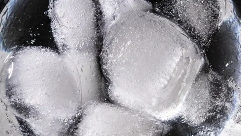Macro Time-Lapse of Frozen Ice Cubes Shifting and Melting in a Glass Stock Footage 339366206