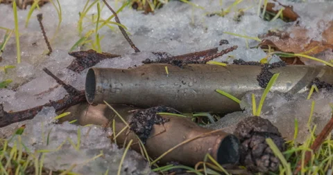 Macro time-lapse shot of shiny melting snow particles and unveiling green grass Stock Footage 169476156