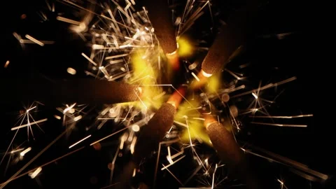 Macro top-down view of several burning sparklers generating bright golden sparks Stock Footage 335387101