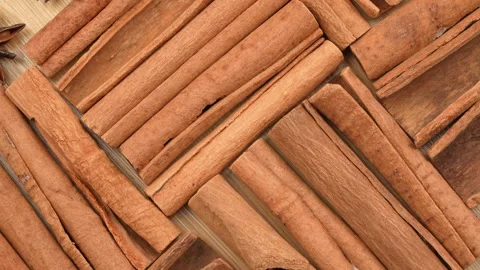 Macro Top View Of Rotating Cinnamon Sticks On Wooden Board Video stock 331379567