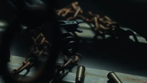 Macro tracking shot of kalashnikov barrel with chains in foreground. moody Stock Footage 337745057