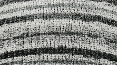 Macro tracking shot of monochrome knit fabric shifting gently to reveal textured Stock Footage 337550446