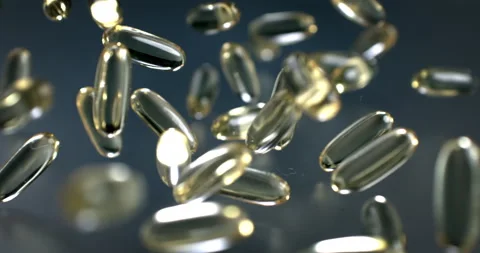 Macro of transparent softgel vitamins capsules falling on grey mirroring surface Stock Footage 269333775