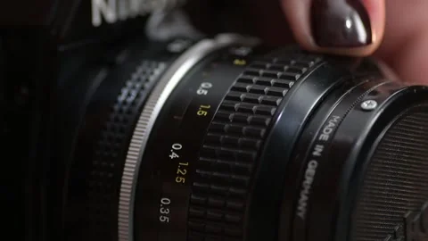 Macro of turning a lens adjustment focus ring of an old retro film camera Stock Footage 281097948