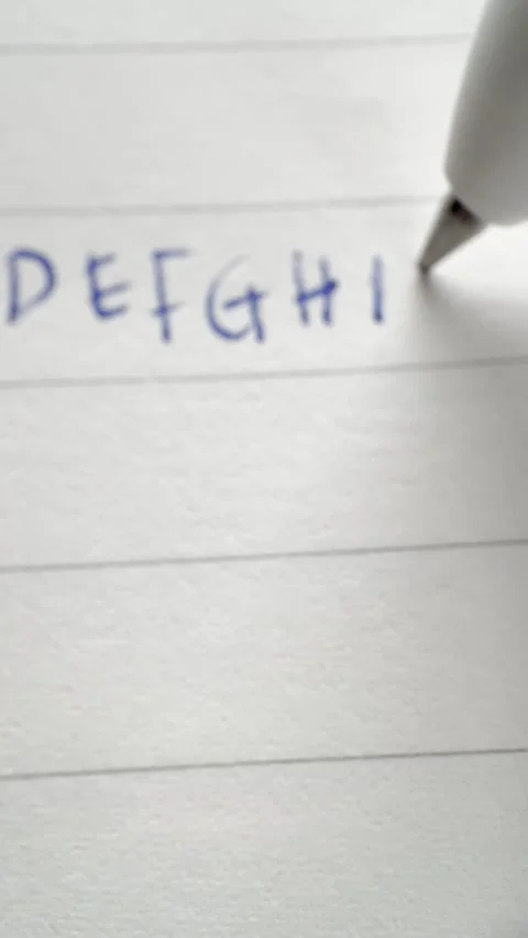 Macro Vertical Video Writing Capital Letters on Lined Paper Stock Footage 334574794