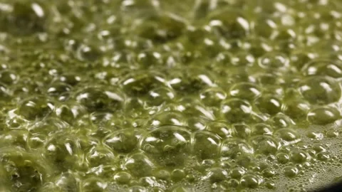 Macro video of boiling butter. boiling oil close up. The butter melts in the pan Stock Footage 153994436