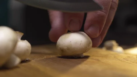 Macro video of the cook slices raw champignons on the wooden board, cooking the Stock Footage 113802563