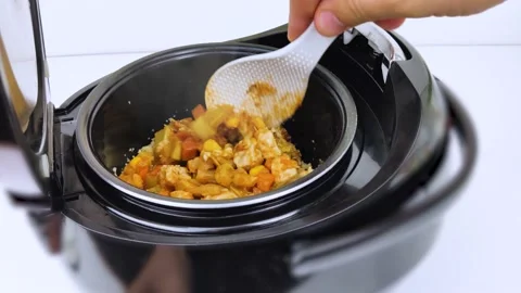 Macro Video of a multicooker. The man opens the pan and mixes the dish. Steam ca Stock Footage 139805791