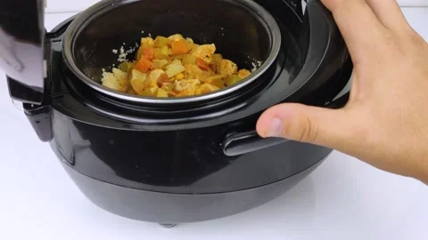 Macro Video of a multicooker. The man opens the pan and mixes the dish. Steam ca Stock Footage 139805806