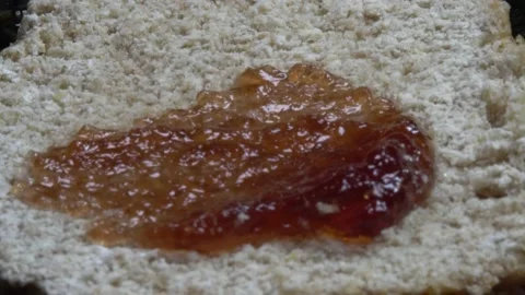 Macro Video Of Person Spreading Jam On Bread In Plain White Light Stock Footage 141472407