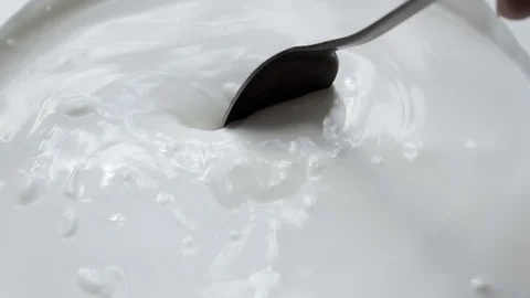 Macro - video shooting,Slow motion of mixing yogurt with spoon in the cup Stock Footage 127996553
