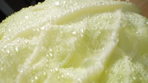 A macro video showcases a green cabbage glistening with droplets of water Stock Footage 244801206