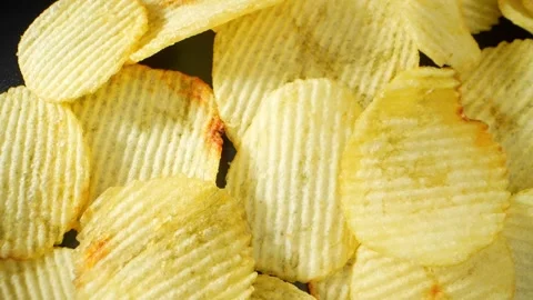 Macro video showcases the mesmerizing details of wavy potato chips Stock Footage 244801449