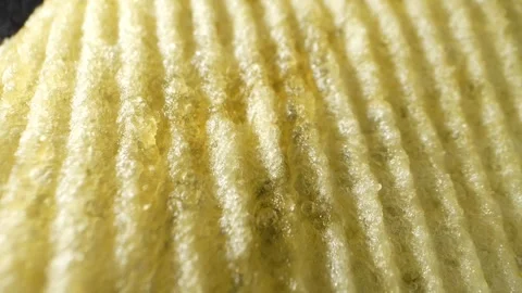 Macro video showcases the mesmerizing details of wavy potato chips Stock Footage 244801504