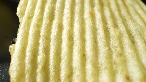 Macro video showcases the mesmerizing details of wavy potato chips Stock Footage 244801505