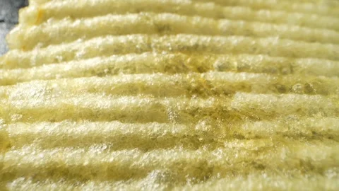 Macro video showcases the mesmerizing details of wavy potato chips Stock Footage 244801511
