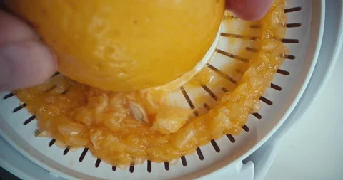 Macro video of squeezing juice from fresh oranges in the kitchen with a juicer. Stock Footage 255058584