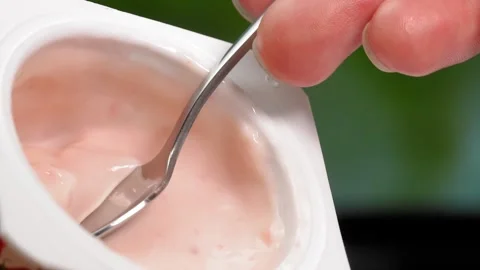 Macro videography, Slow motion yogurt with spoon in cup Stock Footage 248781726