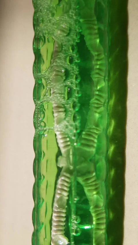 Macro View of Air Bubbles Traveling Through Green Liquid Stock Footage 344873058