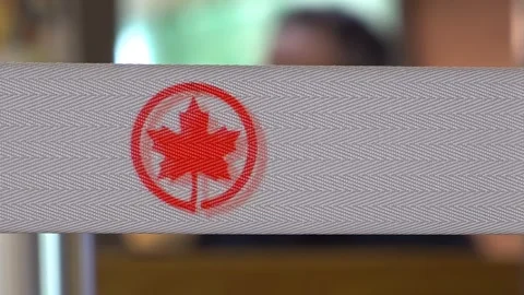 Macro view of Air Canada red maple leaf logo printed on grey fabric ribbon strap Stock Footage 341852390