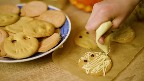 Macro view of applying white chocolate frosting on a shortbread cookie Stock Footage 342704297