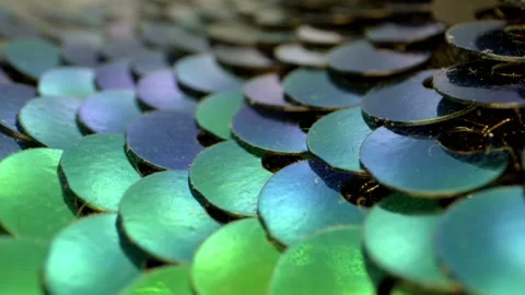 Macro view of an array of blue, teal, and green sequins that are flat and 動画素材 159520014