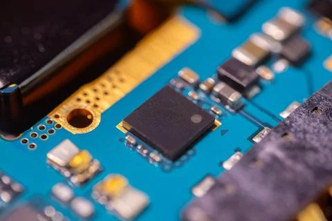 Macro view of black integrated circuit on blue printed circuit board with g.. Stock-Fotos