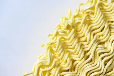 A macro view of a block of dry, yellow, wavy instant ramen noodles, showcas.. Stock Photos