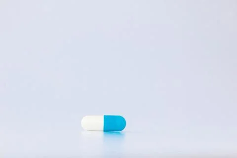 Macro view of blue capsule pill isolated over white background Stock Photos