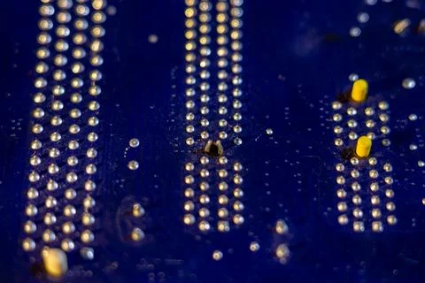 Macro view of blue semiconductor hardware surface featuring rows of bright Stock Photos