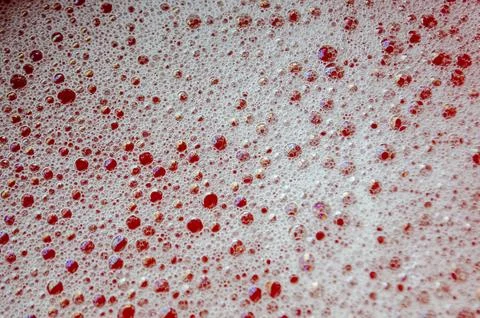 Macro view of bubbles forming on the water surface with red background Stock Photos