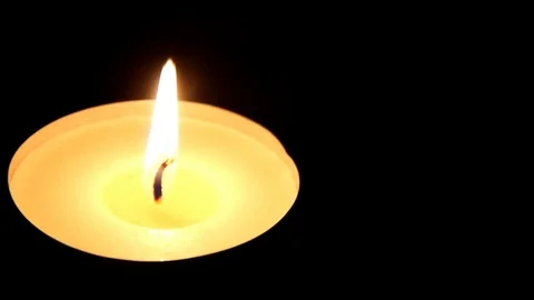 Macro view of of burning candle on black. Camera moves left Stock Footage 74503794