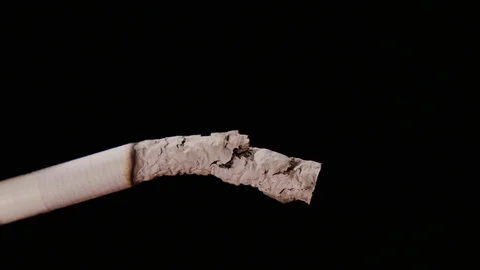 Macro view of burning cigarette with smoke on black. Video could be used as part Stock Footage 77024677