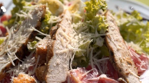 Macro view: Caesar salad with grilled chicken, parmesan cheese and tomatoes Видео 104062620