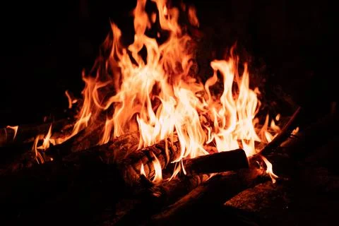 Macro view of a campfire with glowing flames and burning wood. Stock Photos