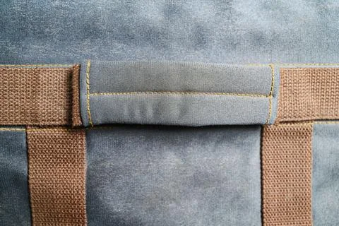 Macro view of a canvas bag handle and brown webbing straps with detailed ye.. Photos
